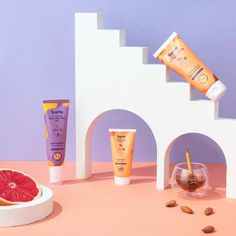 a grapefruit, sunscreen, and body lotion sitting on a table