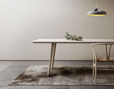 a white table and chair sitting in front of a wall with a plant on it