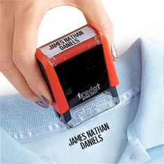 someone is stamping a t - shirt with a red rubber stamper that reads, james nathan daniels