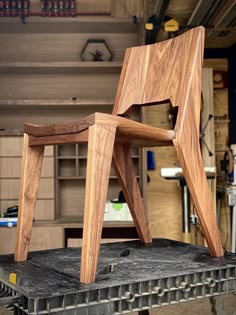 a wooden chair sitting on top of a piece of wood