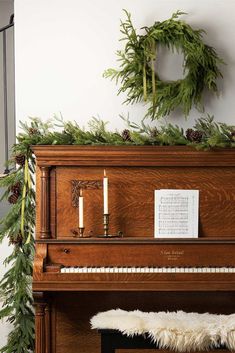 a piano with greenery on top and welcome winter written in white text above it