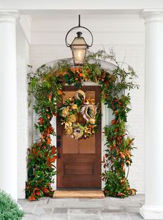 the front door is decorated with greenery and wreaths