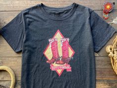 This cowgirl boots womens western graphic tee is perfect for your next rodeo! Classic red Stovetop cowboy boots and vintage spurs adorn this fun western design. Keep it ranchy! 🌵 Quality T-shirt made from 100% ringspun cotton. (Heather colours contain 15% polyester).  🌵 Regular cut. 🌵 Please be aware that some monitors may show some variance from actual colours.   🌵 I also have this same design in other options:      🌵 Check out my other western themed graphic t shirts and hoodies via the l Cowboy Boots Graphic, Wild West Cowgirl, Womens Graphic Tee, Cowgirl Gifts, T Shirt Womens, Western Graphic Tees, Rodeo Shirts, Meme Design, Western Design