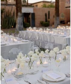 the tables are set with white flowers and candles