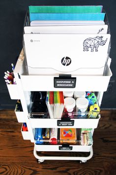 a white cart filled with office supplies on top of a wooden floor