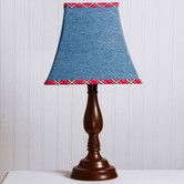 a wooden lamp with a blue shade on it's base and a white wall in the background