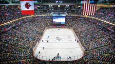 an aerial view of a hockey stadium with the canadian flag on the ice and people watching