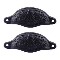 two black handles with ornate designs on them, one has a hole in the middle