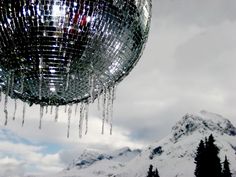 icicles hanging from the ceiling of a disco ball in front of snow covered mountains