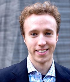 a man in a suit smiling at the camera