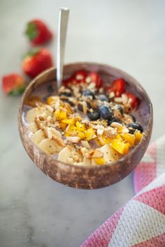 a bowl filled with cereal and fruit on top of a table