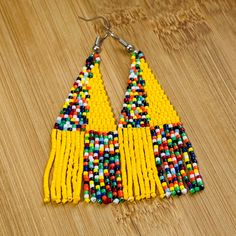 These African Maasai Zulu Style inspired Tribal earrings are definitely a standout. If you love African jewelry styles and these statement earrings, these are your earrings. Yellow Beaded Drop Earrings For Festival, Yellow Beaded Earrings With Ear Wire For Festivals, Yellow Festival Beaded Earrings, Unique Colorful Beaded Earrings, Bohemian Yellow Drop Earrings, Yellow Bohemian Dangle Earrings, Yellow Teardrop Earrings With Dangling Beads, Yellow Single Dangle Earring, Single Yellow Dangle Earring