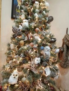 a small christmas tree decorated with owls and pine cones