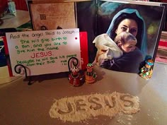 a table topped with pictures and candles next to a sign that says jesus on it