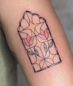 a tattoo on the arm of a woman with a stained glass window in it's center