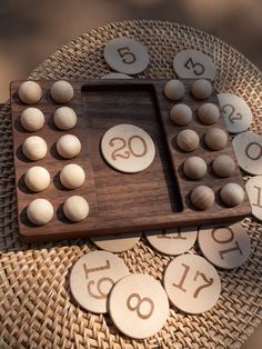 a wooden board game with numbers on it sitting on a wicker tablecloth covered plate