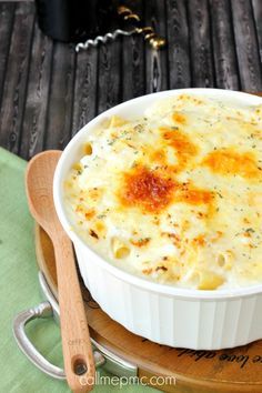 a casserole dish with cheese and parmesan on a wooden serving platter