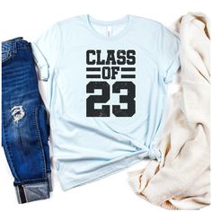 Where are my senior graduates of 2023?! You need to rock this cute, lightly distressed Class Of 2023 shirt. It is the perfect gift for any senior in your life. The lightly distressed design is very trendy but it also has a classic varsity letter font. This soft cotton short sleeve tee is unisex (not fitted) and fits true to size. Soft cotton and quality print will make the buyer fall in love with it over and over again. These t-shirts are very comfortable and will make a great back to school tea Graduation T-shirt With Letter Print In Relaxed Fit, Casual Graduation Shirt With Text Print, Casual Letter Print Shirt For Graduation, Casual Shirt With Text Print For Graduation, School Spirit Shirt With Graphic Print For College Events, School Spirit Cotton Tops For Graduation, Cotton Tops For Graduation With School Spirit, Graphic Print Shirt For College Events, Casual Letter Print Top For Graduation