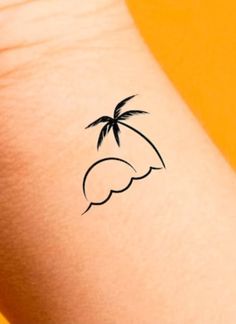 a small palm tree tattoo on the left inner arm and wrist is shown in black ink