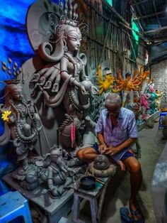 an old man sitting in front of a statue