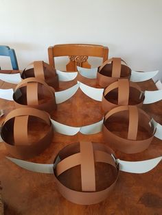 a table topped with lots of brown and white paper circles sitting on top of a wooden table