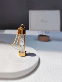 a small gold lighter sitting on top of a white table next to a laptop computer