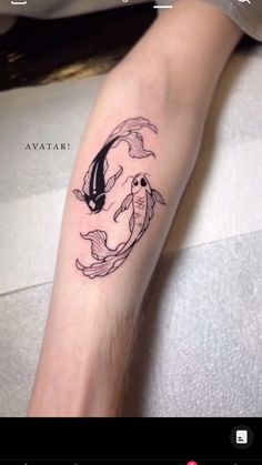 a person with a tattoo on their arm that has two koi fish in it