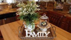 a wooden table topped with a tray filled with flowers