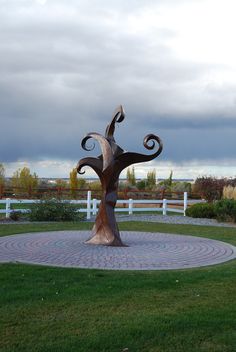 a sculpture in the middle of a grassy area