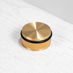 a gold colored grinder sitting on top of a white table