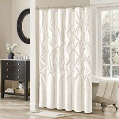 a white shower curtain in a bathroom next to a bathtub and window with curtains