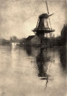 an old photo of a windmill in the water