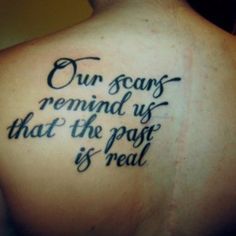 a person with a tattoo on their back saying our scars remind us that the past is real