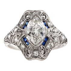 an antique style diamond and blue sapphire ring with filigrees on the sides