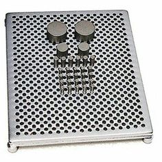 four screws are placed in the middle of a metal tray with holes on it