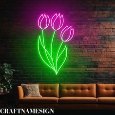 a neon sign with three tulips in front of a brick wall and couch