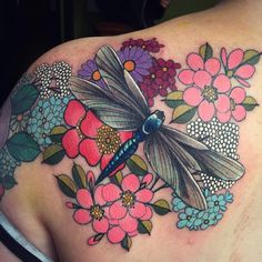 the back of a woman's shoulder with flowers and a dragonfly on it