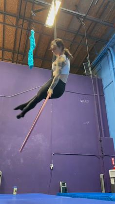 a woman is doing aerial tricks on a trampoline