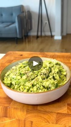 a bowl filled with broccoli on top of a wooden table