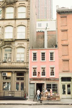 people are sitting at tables in front of buildings