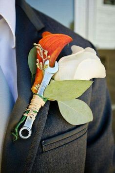 a boutonniere with an orange and white flower attached to the lapel of a suit