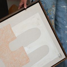 a person holding up a painting with the letter s in it's center and bottom corner