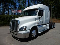 a white semi truck parked in a parking lot