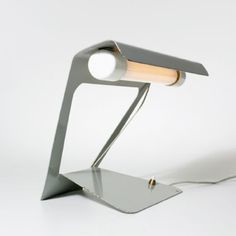 a desk lamp with a white light on it's side and a silver base