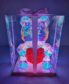 an illuminated gift box with a heart in it and a bow on the top,