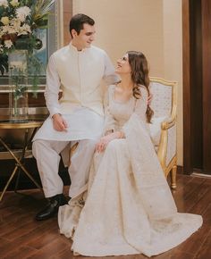 a bride and groom sitting on a chair