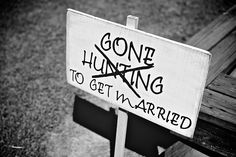 a sign that says, gone hunting to get married on a bench in the grass