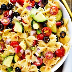 a white bowl filled with pasta salad on top of a table