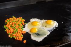 two eggs and some carrots on a grill