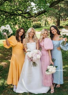 three bridesmaids pose with their bouquets in the park